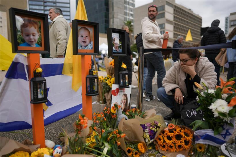 Eine Frau trauert an einer Gedenkstätte auf dem „Geiselplatz“ in Tel Aviv um die toten Geiseln, die junge Mutter Schiri Bibas, ihre beiden kleinen Kinder Ariel und Kfir und den alten Mann Oded Lifshitz
