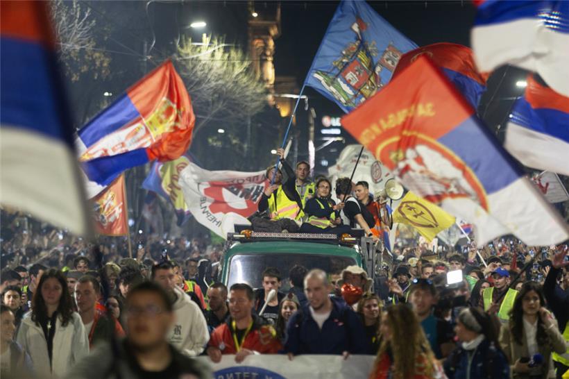 Eine Gruppe von Studenten schwenkt Fahnen, als sie zu einer Demonstration vor einer Anti-Korruptions-Kundgebung in Belgrad ankommt
