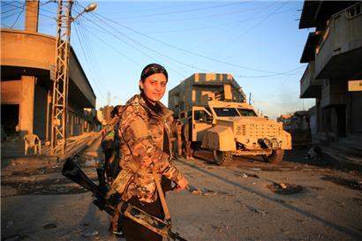 Eine Kämpferin der Syrischen Demokratischen Kräfte steht an einem Kontrollpunkt in Al-Hassaka
