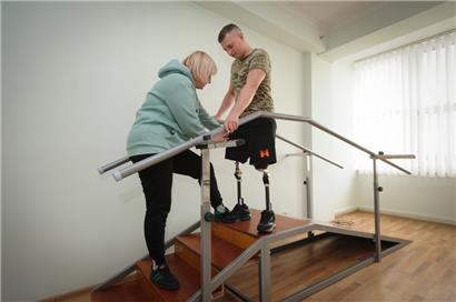 Eine Krankenpflegerin trainiert mit dem ukrainischen Soldaten Dmytro (27), der in einem Gefecht mit russischen Truppen beide Beine verloren hat, in einem Rehabilitationszentrum in der Nähe von Lwiw
