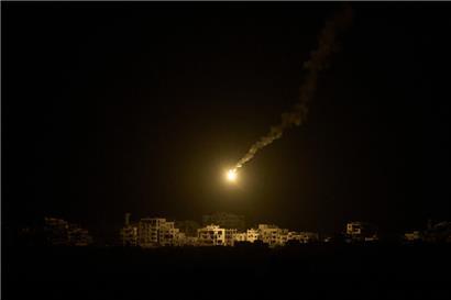 Eine Leuchtrakete der israelischen Armee über Gebäuden, die während der israelischen Boden- und Luftoperationen im nördlichen Gazastreifen zerstört wurden
