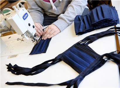 Eine Mitarbeiterin in der Werkstatt für behinderte Menschen in Essen näht eine Atemschutzmaske. Auch in Luxemburg könnten Freiwillige bald ähnliche Masken produzieren. 
