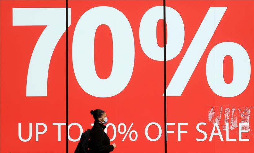 Eine Passantin geht an einem Verkaufsschild an einem geschlossenen Laden in der Oxford Street vorbei.
