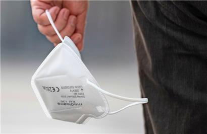 Eine Passantin trägt eine FFP2-Maske in der Hand
