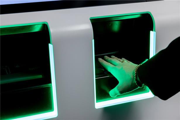 Eine Person legt am Flughafen Düsseldorf die Hand auf einen Scanner zur Erfassung biometrischer Daten
