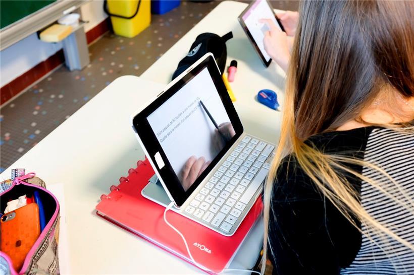 Eine Schülerin sitzt mit ihrem Tablet in einer sogenannten iPadklasse und löst Rechenaufgaben
