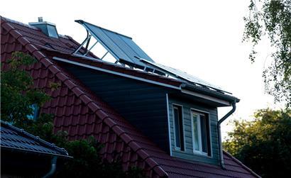 Eine Solaranlage steht auf dem Dach eines Wohnhauses
