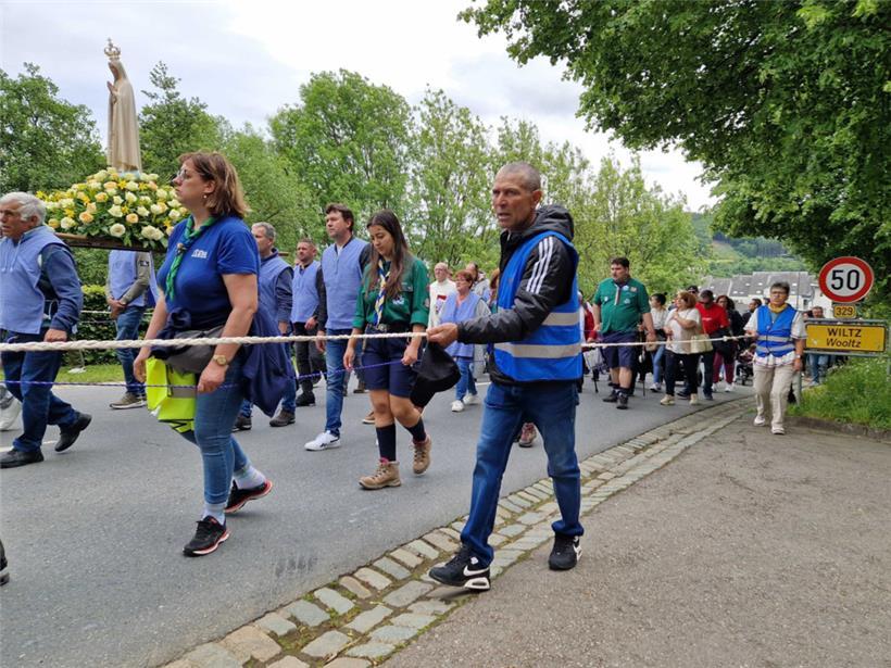 Eine Statue der Jungfrau Maria wird an der Spitze der Prozession von Freiwilligen getragen
