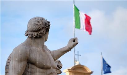 Eine Statue steht vor dem Palazzo del Quirinale in Rom, dem Sitz des Präsidenten von Italien, auf dessen Dach die Flaggen Italiens und der EU wehen
