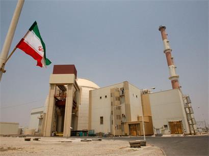 Eine iranische Flagge flattert vor dem Reaktorgebäude des Kernkraftwerks Buscher