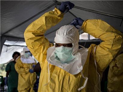 Medizinische Fachkraft zieht persönliche Schutzausrüstung an vor Ebola-Behandlungszentrum für Infektionsschutz