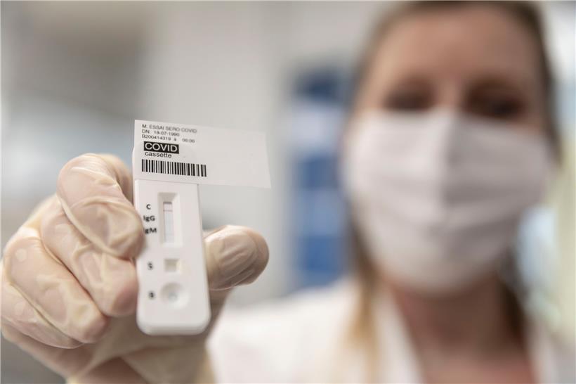 Eine medizinische Mitarbeiterin zeigt einen Covid-19-Test für ältere Menschen in einem Labor. 
