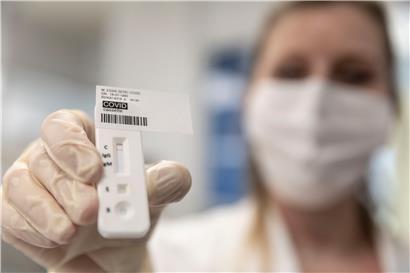 Eine medizinische Mitarbeiterin zeigt einen Covid-19-Test für ältere Menschen in einem Labor. 
