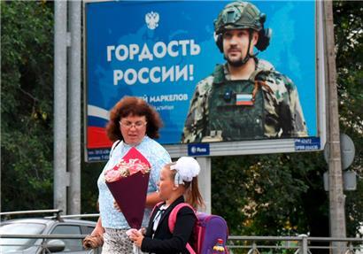 Eine russische Schülerin geht am ersten Tag des neuen Schuljahres in Sankt Petersburg an einem Plakat zu Ehren eines russischen Soldaten vorbei
