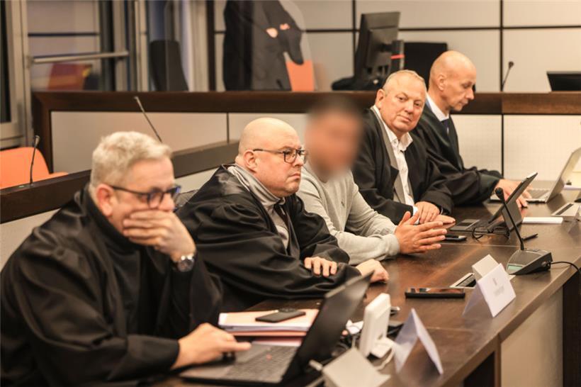 Einer der drei Angeklagten (M) sitzt vor der Urteilsverkündung im Gerichtssaal des Amtsgerichts zwischen Anwälten. Für die gescheiterte Erpressung der Familie von Ex-Formel-1-Rennfahrer Michael Schumacher hat die Justiz gegen drei Angeklagte bis zu drei Jahre Haft verhängt.
