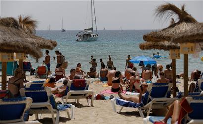 Einheimische und Touristen liegen am Strand Cala Major in Palma de Mallorca
