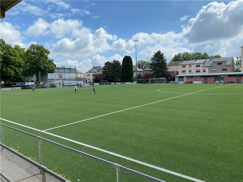Einige Klassen machen Pause auf dem Fußballplatz neben der Schule
