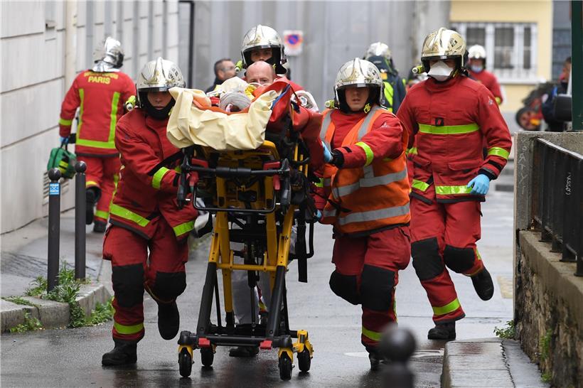 Einsatzkräfte der Feuerwehr schieben eine Trage mit einem Verletzten
