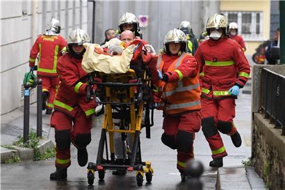 Einsatzkräfte der Feuerwehr schieben eine Trage mit einem Verletzten
