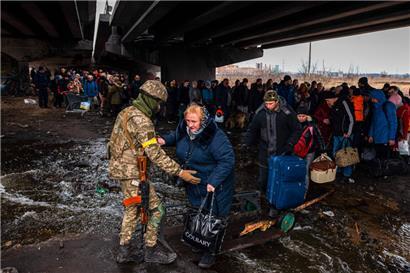 Einwohner aus Irpin auf der Flucht: Der Weg aus der Stadt westlich von Kiew führt unter einer zerstörten Brücke entlang
