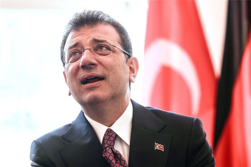 Ekrem Imamoglu, Oberbürgermeister von Istanbul, steht bei einem Empfang im Rathaus vor einer türkischen Fahne
