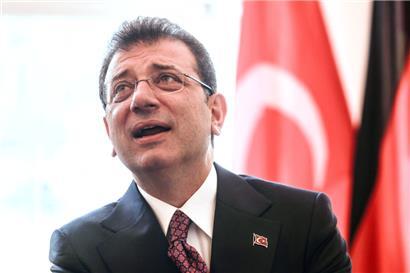 Ekrem Imamoglu, Oberbürgermeister von Istanbul, steht bei einem Empfang im Rathaus vor einer türkischen Fahne
