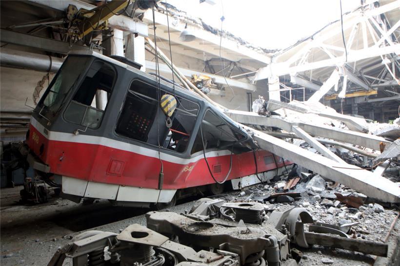 Elemente des Daches eines Gebäudes des Saltiw-Straßenbahndepots liegen in Charkiw nach Raketenbeschuss des russischen Militärs auf einer zerstörten Straßenbahn
