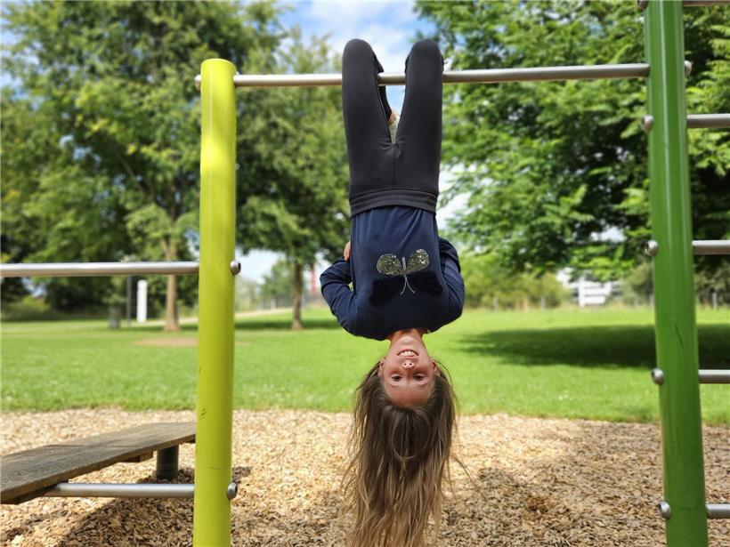 Eline klettert mutig und fit, betrachtet die Welt aus ungewöhnlicher Perspektive von unten nach oben.