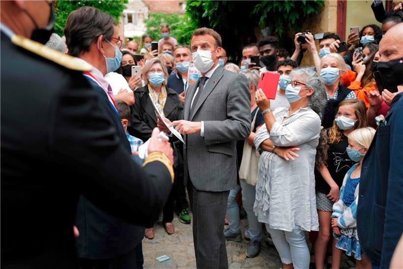 Emmanuel Macron (centre) entamait sa série de visites hier à Saint-Cirq-Lapopie près de Cahors au sud-ouest de la France
