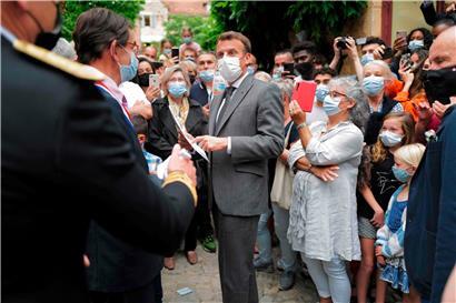 Emmanuel Macron (centre) entamait sa série de visites hier à Saint-Cirq-Lapopie près de Cahors au sud-ouest de la France
