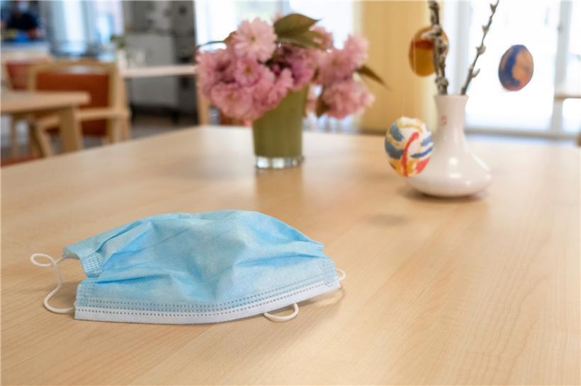 Eng Mask läit op engem Dësch an engem Alters- a Fleegeheem
