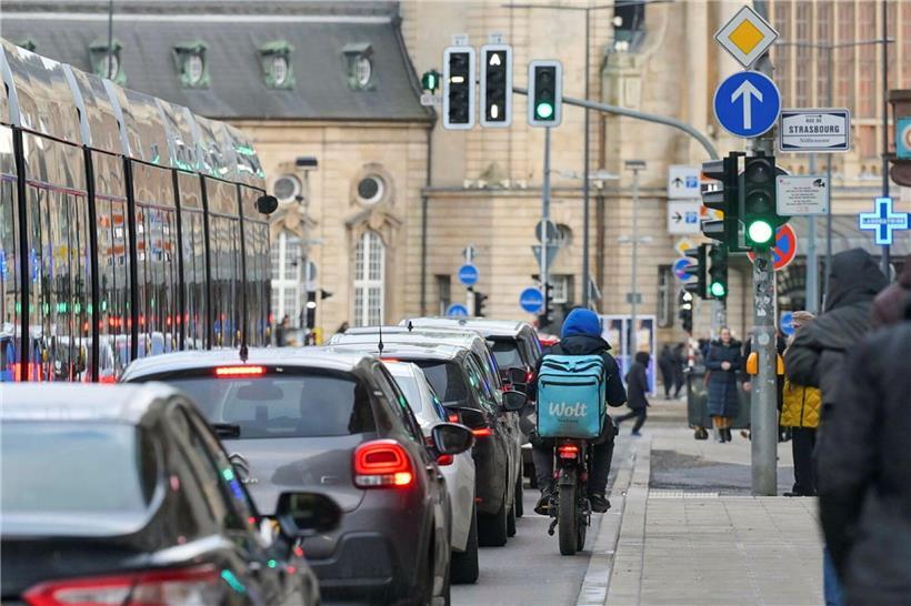 Radfahrer fahren sicher eng an parkenden Autos vorbei – Verkehrssicherheit und Platz für Fahrräder auf der Straße