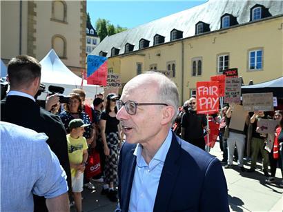 Luc Frieden spricht über ruhige Führung statt hektischer Opgereegtheet, Symbol für besonnenes Regieren und stabile Politik.