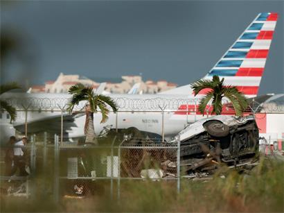 Ermittler gehen am 6. September 2026 am Miami International Airport in Miami, Florida, an beschädigten Fahrzeugen vorbei. Die Fahrzeuge wurden beschädigt, als ein Amazon-Frachtflugzeug abstürzte; bei dem Unfall kamen nach bestätigten Angaben fünf Menschen ums Leben