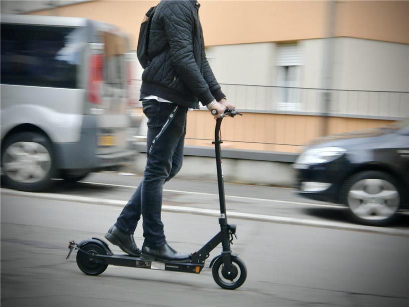 Unfall mit illegalem E-Scooter auf Straße, beschädigtes Fahrzeug und Unfallstelle sichtbar