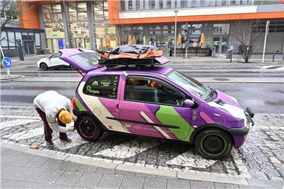Kleines Problem am Escher Bahnhof mit wartenden Reisenden und Zug im Hintergrund