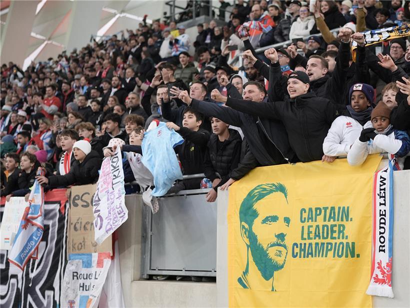 Junge Fußballfans jubeln im Stadion und unterstützen ihren Lieblingsverein begeistert bei einem Spiel.