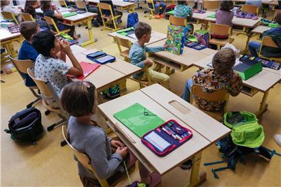 Lehrer im Klassenzimmer sorgt für geregelten Unterricht und konzentrierte Schüler beim Lernen