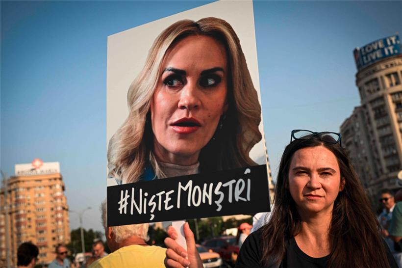 „Es sind Monster“, steht unter dem Bild der rumänischen Familienministerin Gabriela Firea, das eine Frau während einer Protestaktion in Bukarest in die Höhe hält
