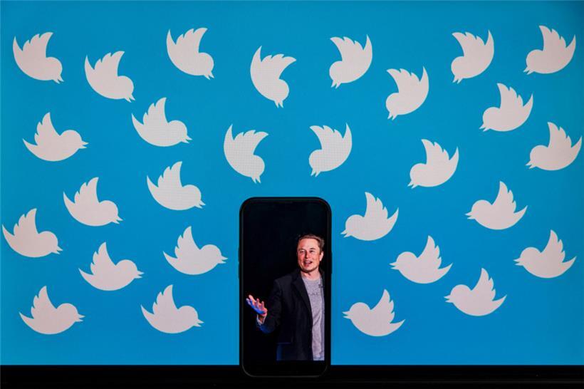 (FILES) This file illustration photo taken on August 5, 2022 shows a cellphone displaying a photo of Elon Musk placed on a computer monitor filled with Twitter logos in Washington, DC. – The New York Stock Exchange suspended trading of Twitter shares on October 4, 2022 following a Bloomberg report on a possible new takeover…
