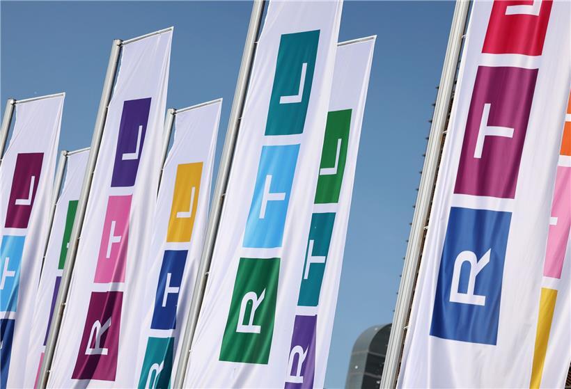 Fahnen mit dem neuen Logo des Fernsehsenders RTL. Die drei Buchstaben des Privatsenders sind schmaler, statt aus den drei Grundfarben Rot, Gelb, Blau sind die drei Blöcke des Logos aus allen möglichen Farben zusammengesetzt.

