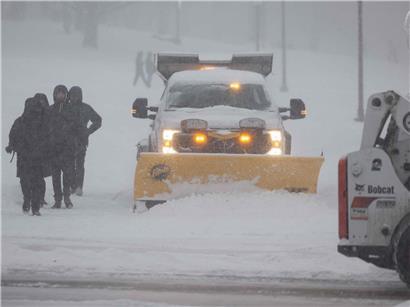 Schneeräumfahrzeuge bei starkem Wintersturm räumen Boston Common am 25. Januar 2026, während Fußgänger durch Schnee gehen