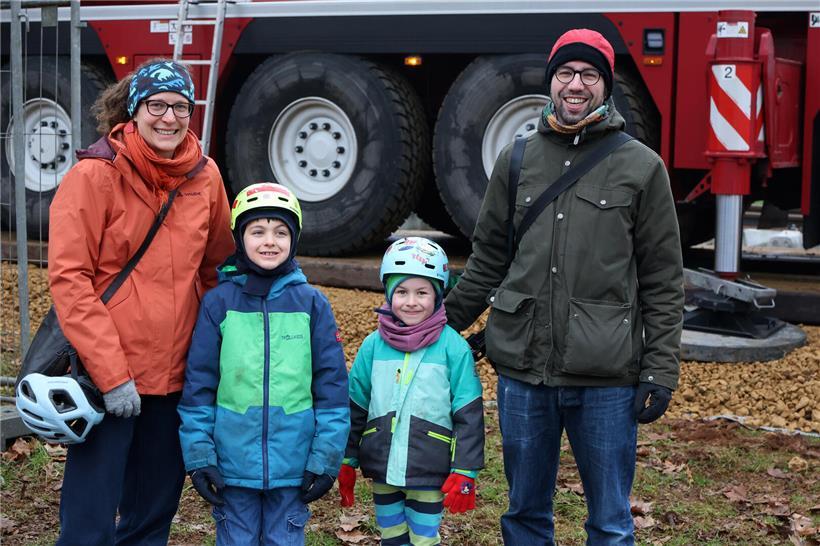 Familie Lucena-Kiefer wartet gespannt auf Lokomotive, Kinder begeistert von großen Lastwagen und Kränen am Bahnhof