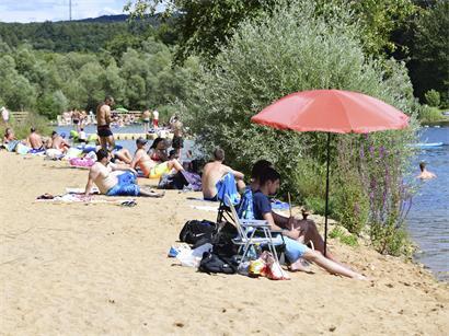 Sonniger Strand mit klarem blauem Wasser und mediterranem Flair, ideal für Urlaub und Entspannung am Meer