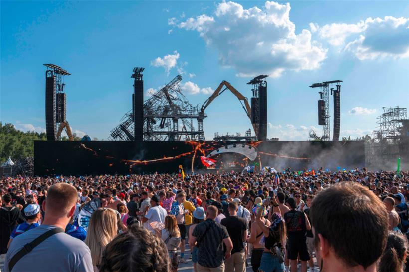 Festivalbesucher versammeln sich vor der ausgebrannten Hauptbühne während ihres Abbaus
