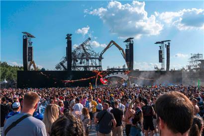 Festivalbesucher versammeln sich vor der ausgebrannten Hauptbühne während ihres Abbaus
