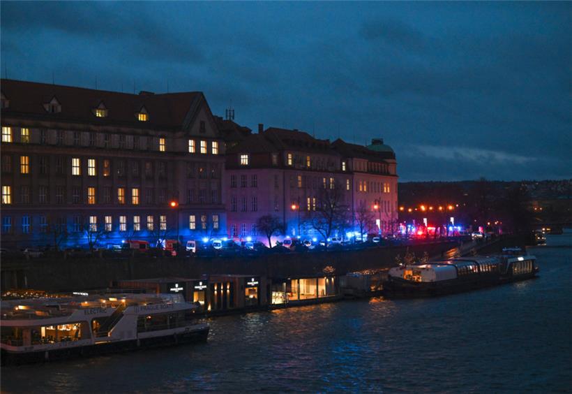 Feuerwehrfahrzeuge und Krankenwagen stehen am Ufer vor der Karls-Universität
