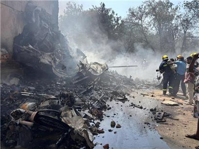 Feuerwehrleute arbeiten an der Absturzstelle eines Flugzeugs in der nordwestlichen Stadt Ahmedabad im indischen Bundesstaat Gujarat
