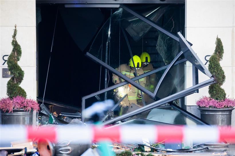 Feuerwehrleute begutachten Trümmer in dem Hotel an der Karl-Liebknecht-Straße