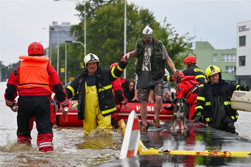 Feuerwehrleute evakuieren Menschen aus einem überfluteten Gebiet im Stadtviertel Mährisch Ostrau. Ganze Regionen in Tschechien leiden unter einem Jahrhunderthochwasser
